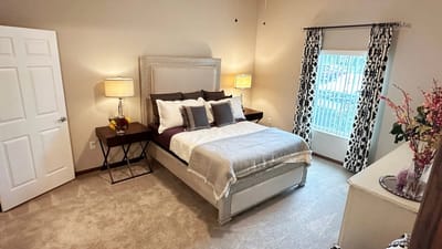 A well-furnished private resident room with a bed and window