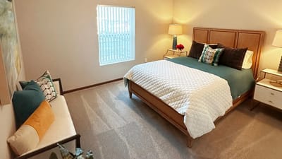 A cozy resident room with a bed and seating area
