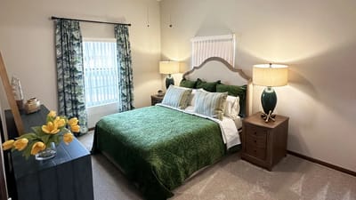 Cozy bedroom setup with green bedding and decor