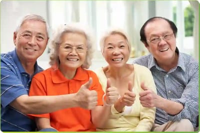 Four seniors giving thumbs up together