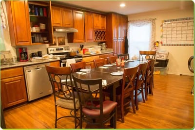 Kitchen area with large dining table and appliances.