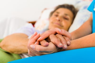 Caregiver holding a resident's hand