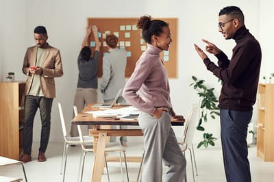 People engaged in a casual discussion in an office-like space.