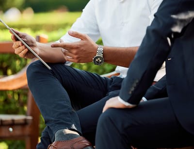 Close-up of men discussing with a tablet