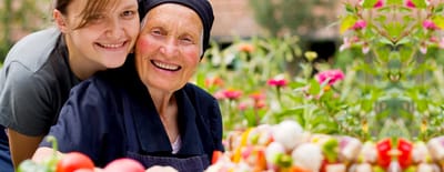 Resident and staff member gardening together in a vibrant garden