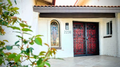 Exterior view featuring ornate doors and stained glass window