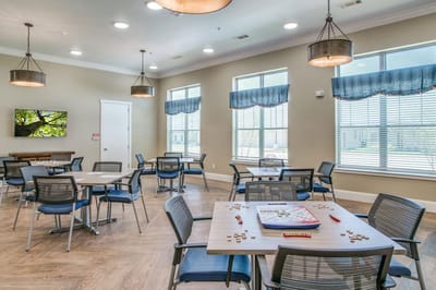Bright common area with tables and chairs for activities