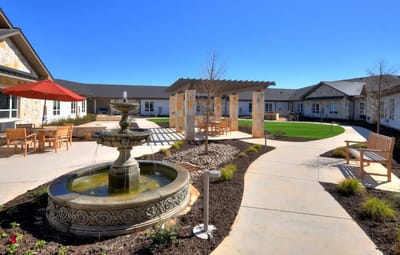 A serene outdoor courtyard with a fountain and seating