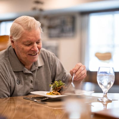 Resident enjoying a meal in the dining room