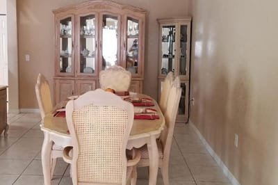 A dining room set with a table and chairs