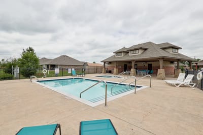 Outdoor pool area with seating and nearby buildings
