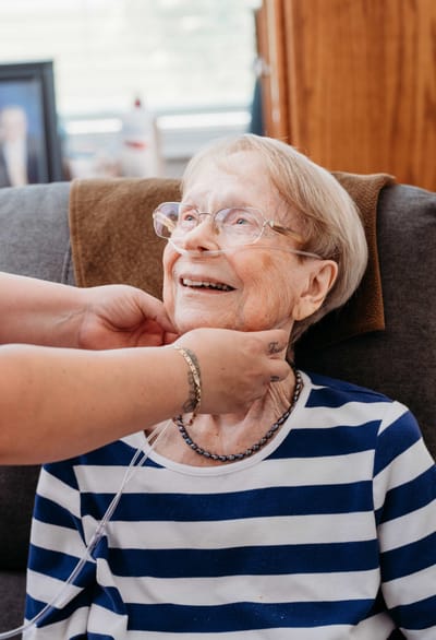 Senior woman smiling with caregiver assistance