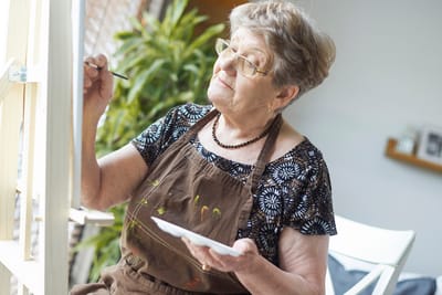 Senior woman painting in an artistic activity