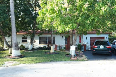 Exterior view of a small assisted living facility surrounded by greenery