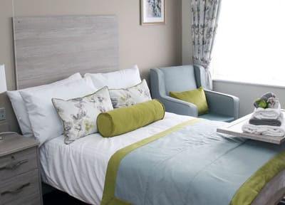 Cozy interior of a resident's room with bed and chair