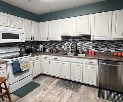 Bright, modern kitchen with white cabinetry and decorative backsplash