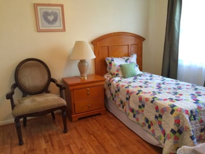 Cozy resident room with a single bed and chair