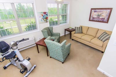 Bright common area with seating and exercise equipment