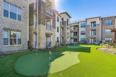 Outdoor green space with putting greens near the building