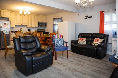Cozy common area with black recliners and dining space