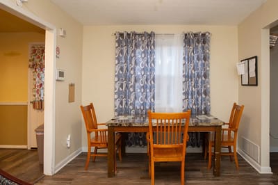 Bright interior dining area with wooden chairs and a table