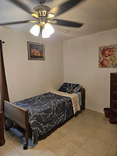A private resident room with a bed and dresser