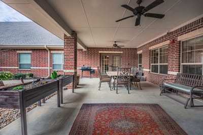Covered patio area with seating and planters