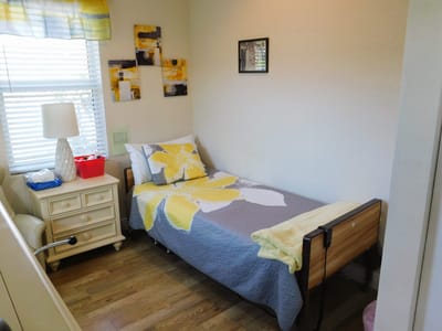 A cozy resident room with a floral blanket