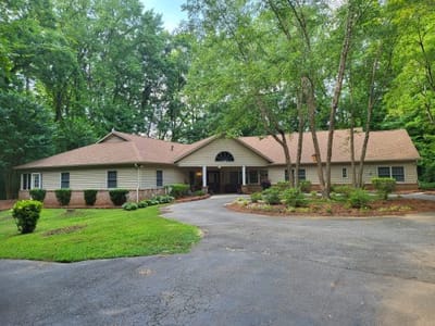 Exterior view of House of Peace facility surrounded by trees