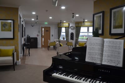 Interior view of a care home common area with a piano