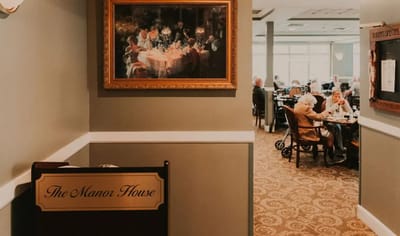 Interior view of dining area with residents and artwork