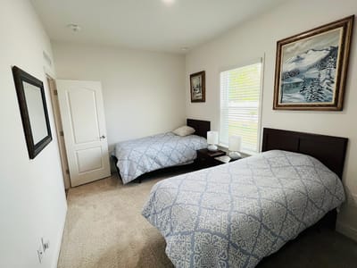 Cozy shared bedroom with twin beds and artwork