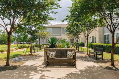 Outdoor seating area with benches and greenery