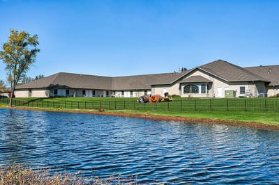 Exterior view of Oak Pointe of Warrenton by a pond