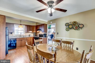 Bright kitchen area with dining table and ceiling fan