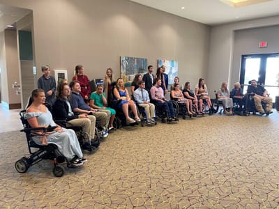 Group of residents and staff in wheelchairs in a common area