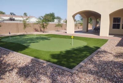 Outdoor putting green surrounded by a landscaped area