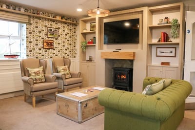 Cozy common area with green sofa and armchairs