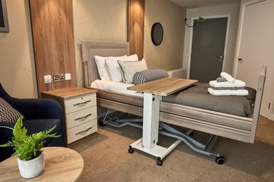A well-furnished resident room with a hospital bed and modern decor