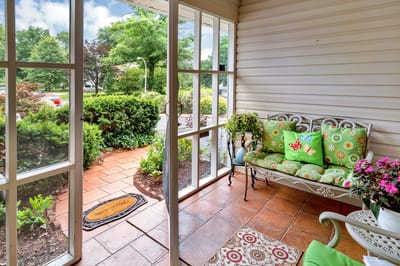Sunny porch area with seating and greenery