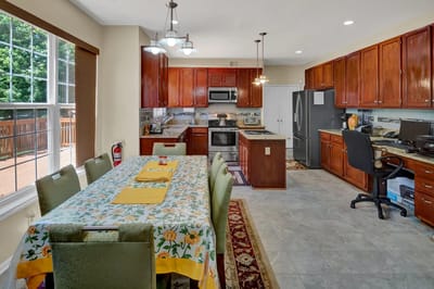 Bright kitchen area with wooden cabinets and a dining table