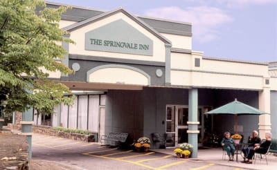 The exterior of Bethel Springvale Inn with residents enjoying the space
