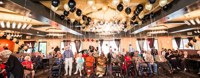Residents celebrating with balloons in a decorated common area