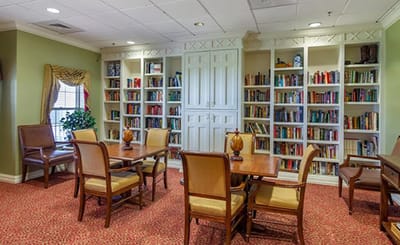 Interior view of a cozy library with bookshelves and tables