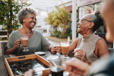 Two elderly women enjoying coffee outdoors