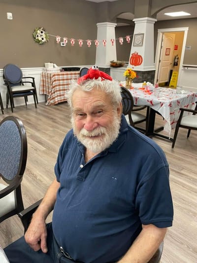 A resident wearing a fun hat in a decorated common area
