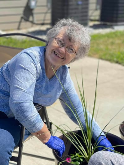 Resident planting flowers in a garden