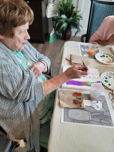 Resident painting in an activity room