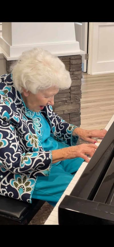 Resident playing piano in a vibrant activity space