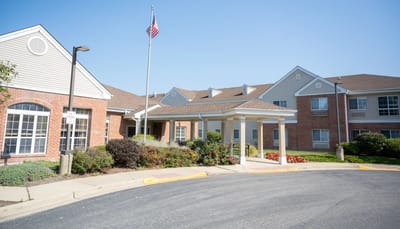 Exterior view of Eden Vista Prospect Heights with flowers and flag